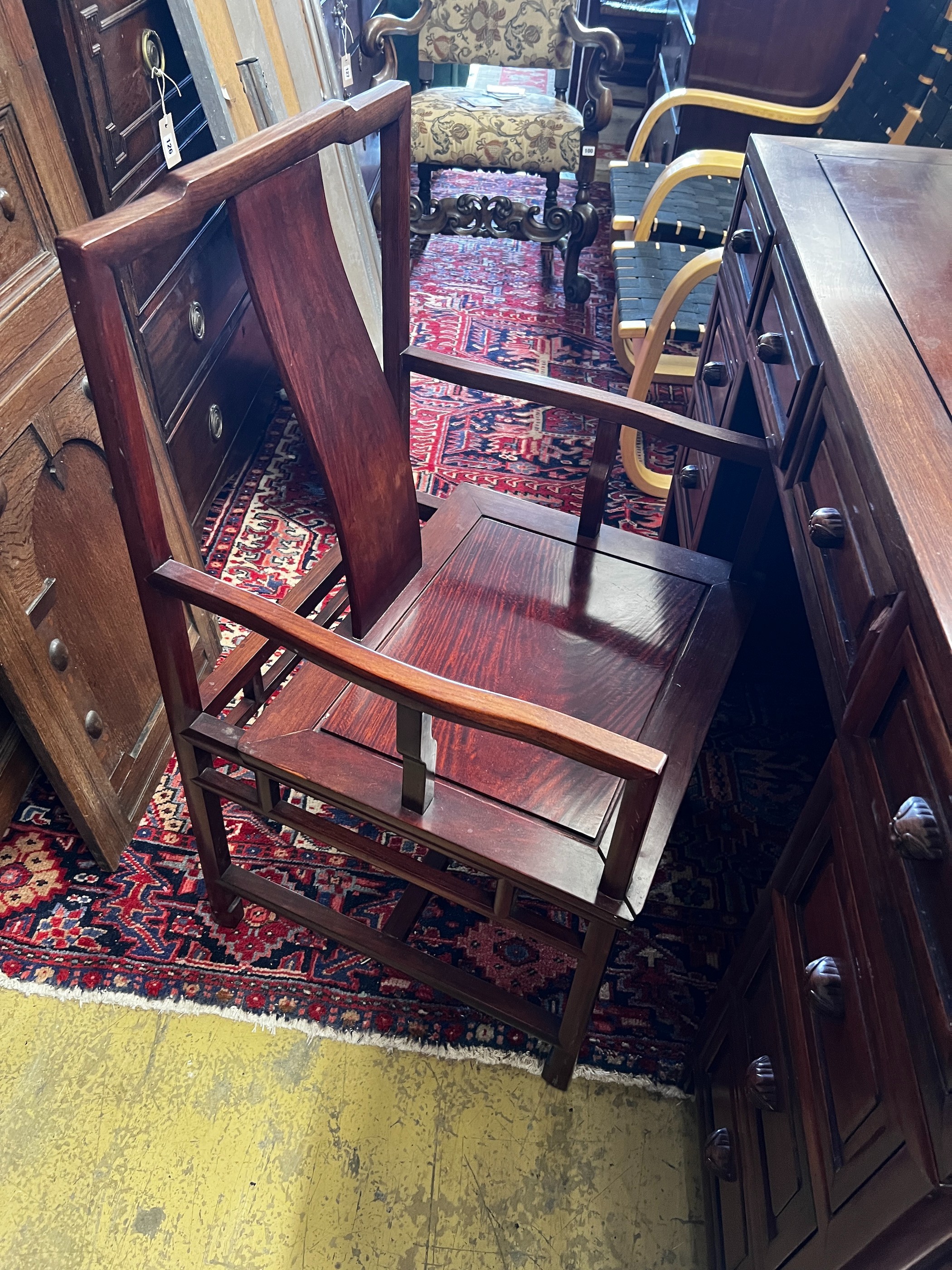 A Chinese hardwood kneehole desk, length 131cm, depth 65cm, height 83cm and elbow chair